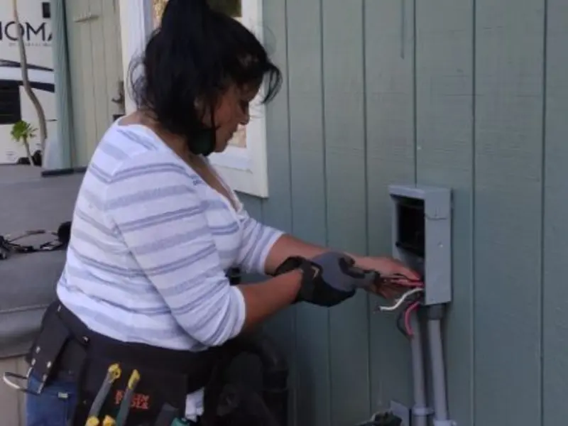 Licensed electrician wiring an exterior subpanel in Solvay